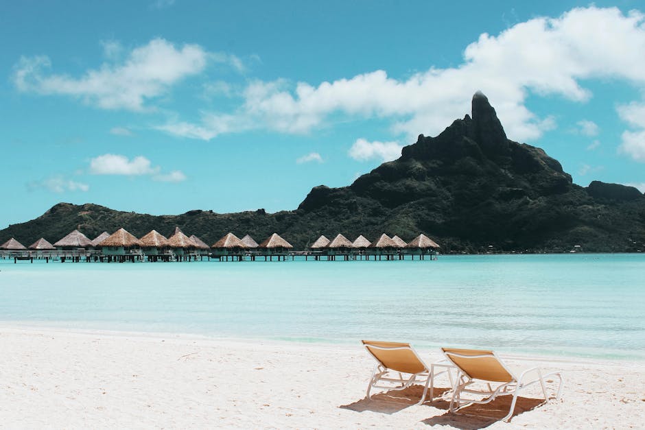 Pristine beach with loungers facing turquoise waters and iconic Mount Otemanu in French Polynesia